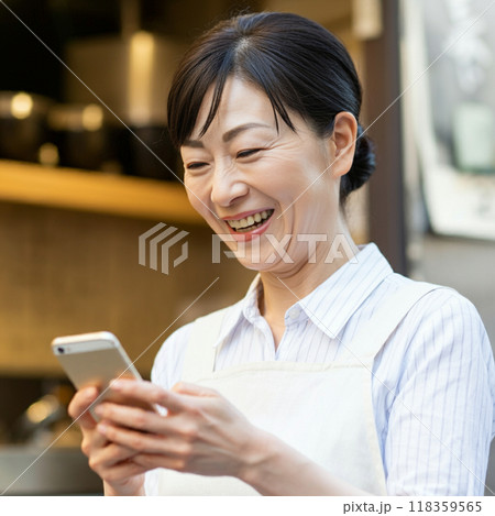 スマホ　笑顔　女性　エプロン 118359565