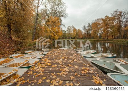 Autumn landscape background with old wooden pier and boat on lake Autumn landscape background with old wooden pier and boat on lake 118360683