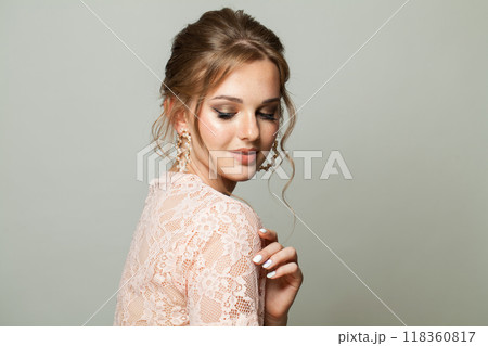 Cute glam woman fashion model with makeup and updo hairstyle on gray studio background 118360817