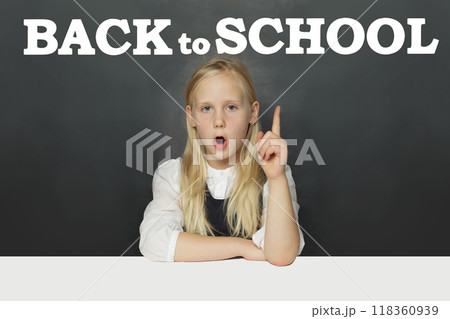 Little school girl child student showing Back to school inscription on blackboard background. Little school girl child student showing Back to school inscription on blackboard background. 118360939