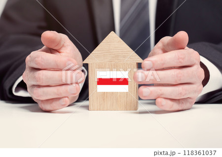 Businessman hand holding wooden home model with Belorussian flag. insurance and property concepts Businessman hand holding wooden home model with Belorussian flag. insurance and property concepts 118361037