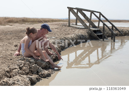 Family on mud geyser resort with therapeutic mud. Young girl and her dad outdoor Family on mud geyser resort with therapeutic mud. Young girl and her dad outdoor 118361049