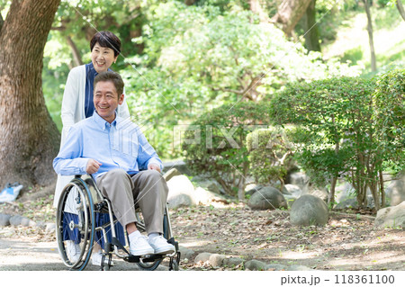 車椅子で散歩するシニア夫婦 118361100