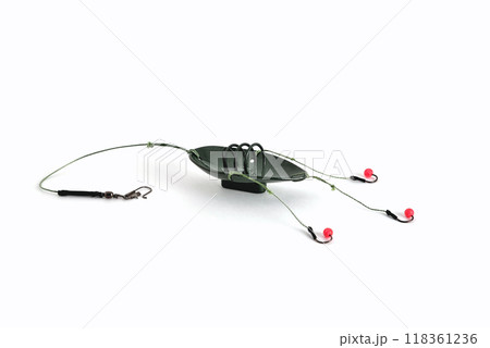 fishing trough spoon, fishing hooks and fishing line, accessories for bottom fishing on a white background close-up fishing trough spoon, fishing hooks and fishing line, accessories for bottom fishing on a white background close-up 118361236