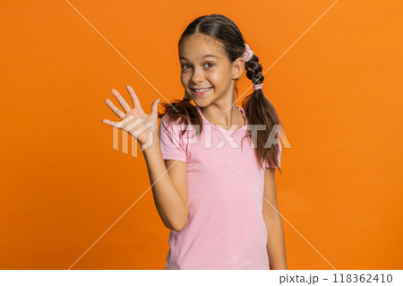 Young cute school girl kid smiling friendly gesturing hello or goodbye, welcoming, waving hands Young cute school girl kid smiling friendly gesturing hello or goodbye, welcoming, waving hands 118362410