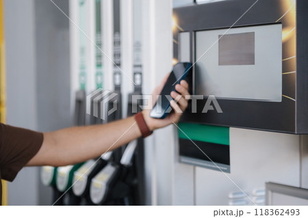 Man pay for petrol on self service gas station using his smartphone. Contactless payment. Close-up. Focus on display Man pay for petrol on self service gas station using his smartphone. Contactless payment. Close-up. Focus on display 118362493
