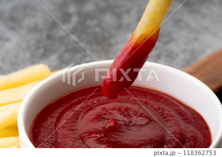 ケチャップにつけて食べるフライドポテトのクローズアップ 118362753