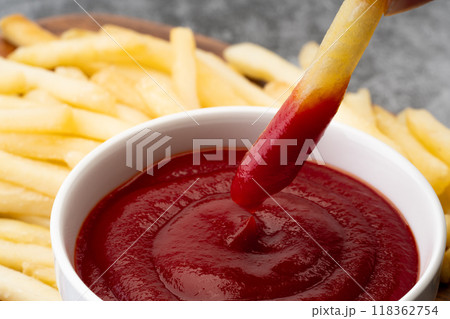 ケチャップにつけて食べるフライドポテトのクローズアップ 118362754