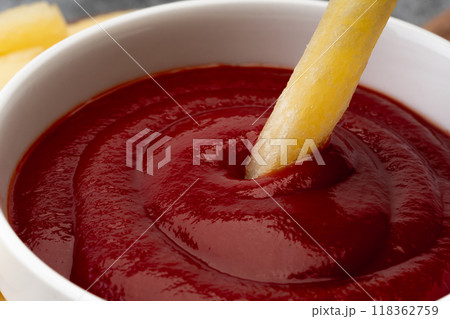 ケチャップにつけて食べるフライドポテトのクローズアップ 118362759