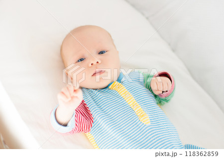 Little baby on white bed 118362859