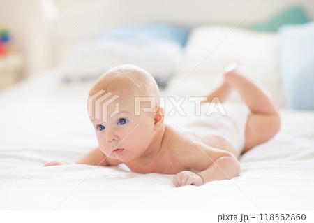 Little baby on white bed 118362860