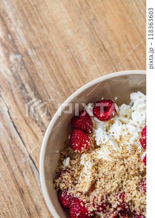 cottage cheese in a bowl with fresh raspberries and ground nuts, top view cottage cheese in a bowl with fresh raspberries and ground nuts, top view 118363603