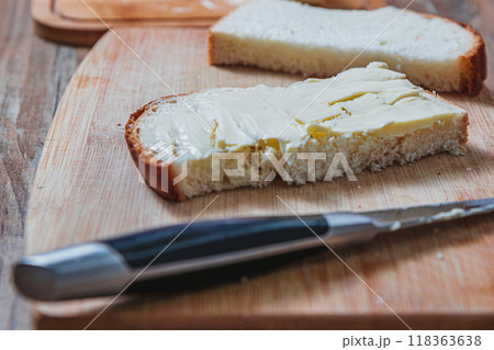 Close-up of buttered slice of white homemade bread out of focus in foreground 118363638