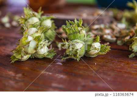 A pile of hazelnuts on a table outside 118363674