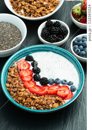 Healthy breakfast . Yogurt with berries ( strawberry , raspberry , blueberry , blackberry ) , granola and chia seeds . Top view 118365024