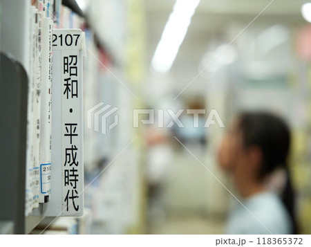 図書館で本を探す小学生の女の子の様子 118365372