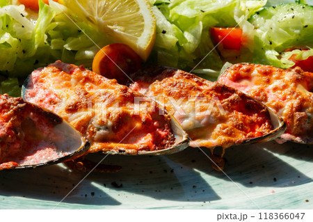 baked mussels with masago caviar and cheese on a white plate 118366047