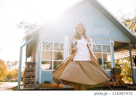Young girl with retro camera enjoying autumn weather. 118367472