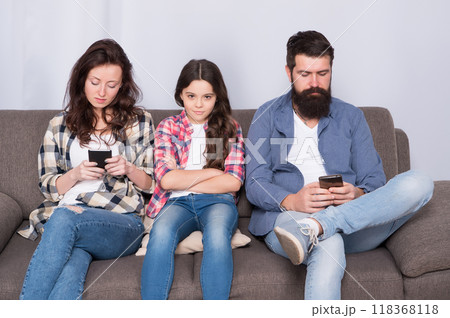 Technology distracting family from child. Small child and parents picking up phones. Unhappy child and family at home. Parenthood and childhood. Childcare. Taking care of child Technology distracting family from child. Small child and parents picking up phones. Unhappy child and family at home. Parenthood and childhood. Childcare. Taking care of child 118368118