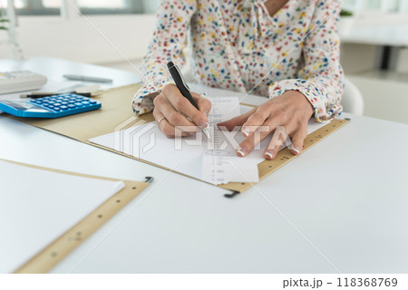 Accountant summing up the numbers writing on a printout receipt 118368769
