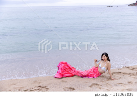 海の砂浜に寝そべる若い女性の人魚 118368839