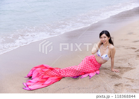 海の砂浜に寝そべる若い女性の人魚 海の砂浜に寝そべる若い女性の人魚 118368844