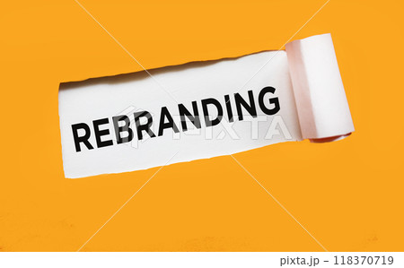 The text REBRANDING appears behind torn orange paper. The text REBRANDING appears behind torn orange paper. 118370719