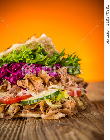 Doner Kebab Doner Kebap fast food snack in flatbread on a wooden table Doner Kebab Doner Kebap fast food snack in flatbread on a wooden table 118370881