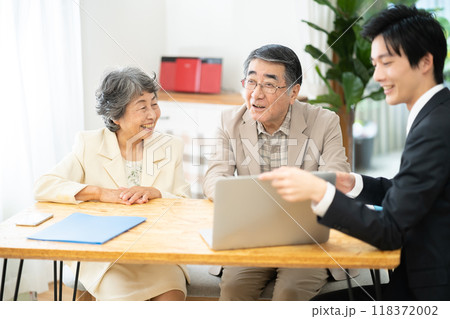 リフォーム相談をするシニア夫婦　シニア夫婦に営業するビジネスマン 118372002