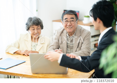 リフォーム相談をするシニア夫婦　シニア夫婦に営業するビジネスマン 118372010
