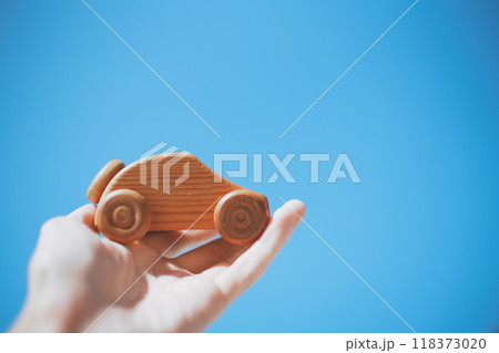 木製の車を持つ人の手と青空背景 木製の車を持つ人の手と青空背景 118373020