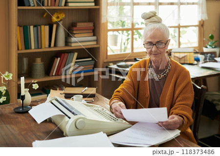 Senior Woman Reviewing Documents in Cozy Home Office 118373486