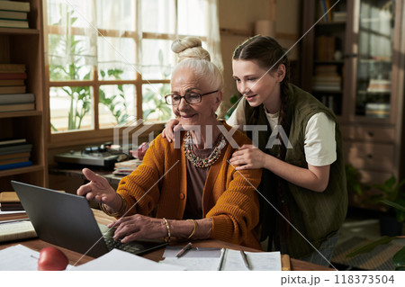 Granddaughter Hugging Grandmother While Using Laptop 118373504