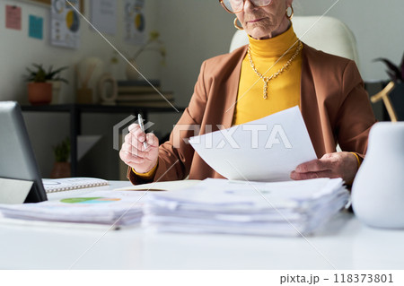 Senior Businesswoman Reviewing Documents in Office Senior Businesswoman Reviewing Documents in Office 118373801