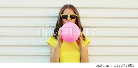 Fashion portrait of stylish cool young woman inflating pink chewing gum or balloon, teenage girl 118373909