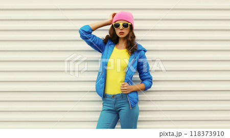 Stylish modern young woman in vivid colorful clothing, pink hat, blue jacket, fashion teenage girl 118373910