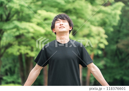深呼吸するスポーツウェア姿の若い男性(森林浴・ストレス解消・気分転換・朝活・準備運動・日光浴) 深呼吸するスポーツウェア姿の若い男性(森林浴・ストレス解消・気分転換・朝活・準備運動・日光浴) 118376601