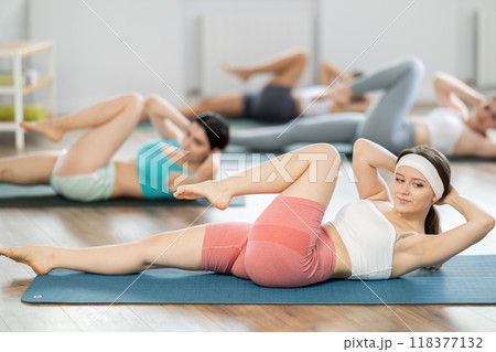 Young girl doing press exercise in pilates studio 118377132