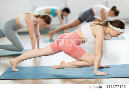 Group of women doing body stretching during Pilates class in studio Group of women doing body stretching during Pilates class in studio 118377166