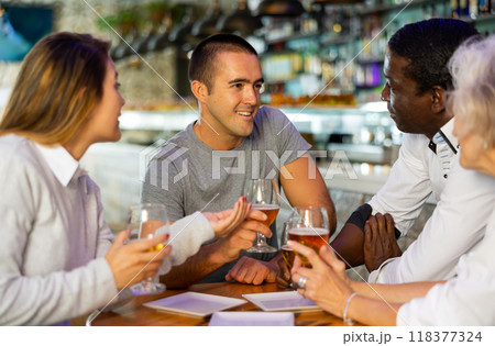 Happy diverse group having a conversation at a bar Happy diverse group having a conversation at a bar 118377324