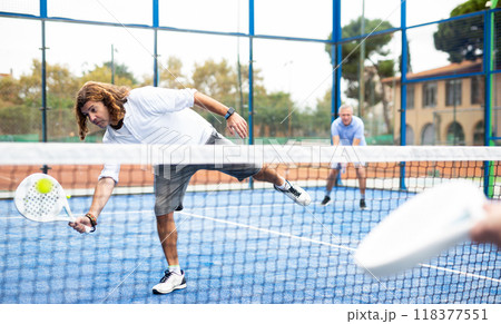 Caucasian man playing paddle tennis on padel court 118377551