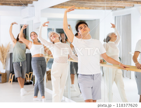Group of different people doing ballet at barre 118377620