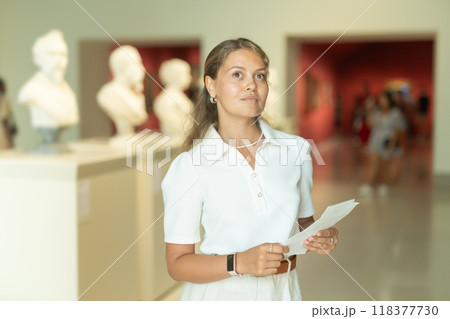 Woman with sheet piece of paper in hands view sculpture in museum hall Woman with sheet piece of paper in hands view sculpture in museum hall 118377730