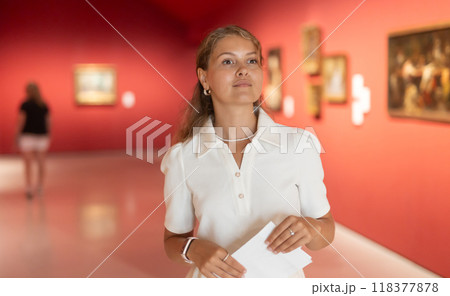 Woman with sheet piece of paper in hands view pictures and icons in museum hall 118377878