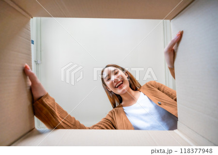 Low angle view of surprised young asian woman unpacking Low angle view of surprised young asian woman unpacking 118377948
