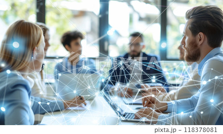 A group of people are sitting around a table with a laptop open A group of people are sitting around a table with a laptop open 118378081