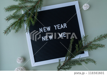 Letter board with inspirational message NEW YEAR NEW ME with fir branches on pastel background. Happy new year promises resolutions. Self growth and personal development Letter board with inspirational message NEW YEAR NEW ME with fir branches on pastel background. Happy new year promises resolutions. Self growth and personal development 118381601