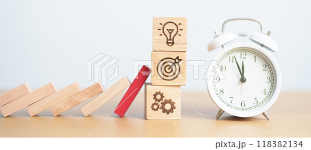 wood block falling to business icon with clock. brainstorming, Target, goal, teamwork and strategy. risk management, financial, deflation and Inflation, Insurance and economic recession wood block falling to business icon with clock. brainstorming, Target, goal, teamwork and strategy. risk management, financial, deflation and Inflation, Insurance and economic recession 118382134