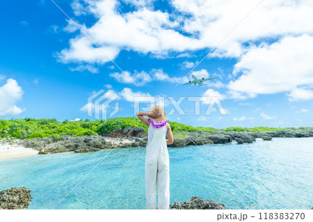 空港に降り立つ旅客機を見上げる女性ポートレート 118383270