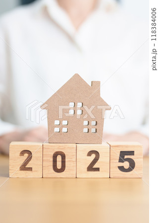 Happy New Year 2025 with house model. real estate, Home loan and mortgage, tax, investment, financial, savings and New Year Resolution concepts 118384006